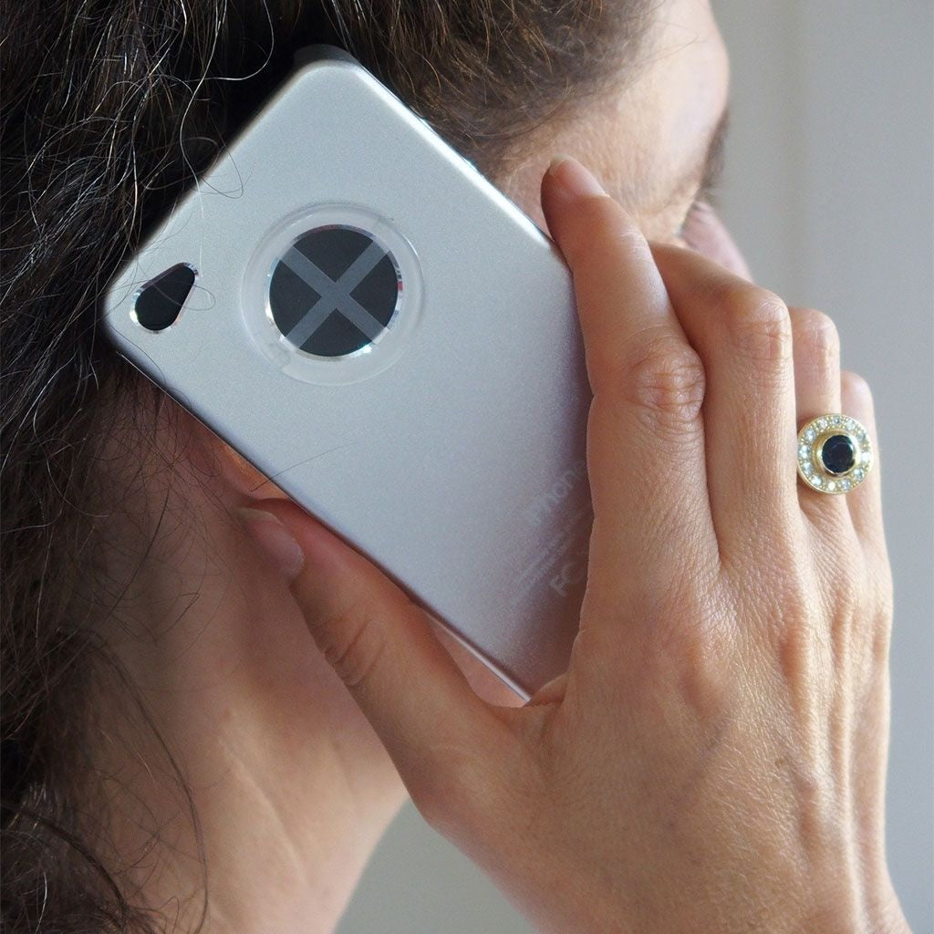 Eine Frau telefoniert mit einem Smartphone, auf dem ein UMH Energy Phone Aufkleber angebracht ist.