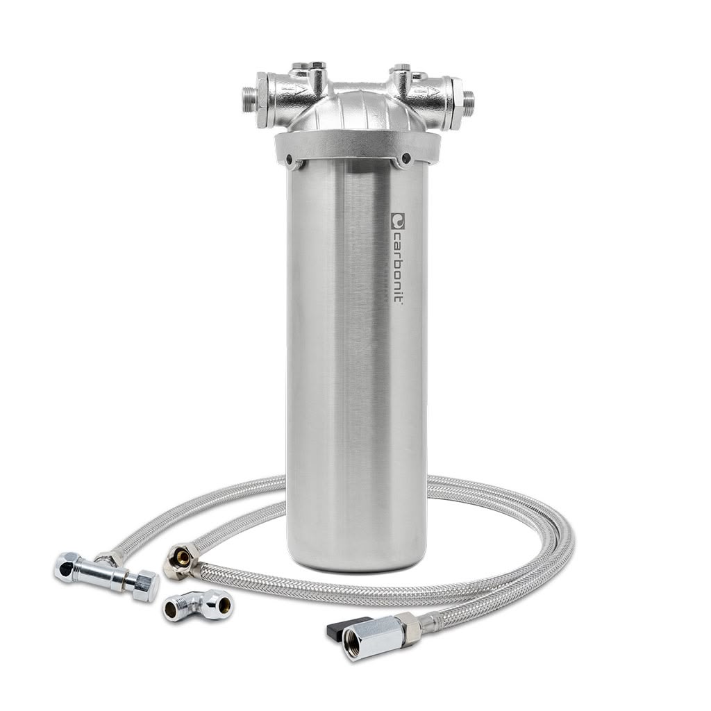 Der Carbonit Vario Inox Basic, ein hochwertiges Untertisch-Wasserfiltergehäuse aus V2A-Edelstahl, steht aufrecht auf weißem Grund mit zwei geflochtenen Metallschläuchen und Armaturen. Das Carbonit-Logo ist an der Seite des hochwertigen Geräts sichtbar.