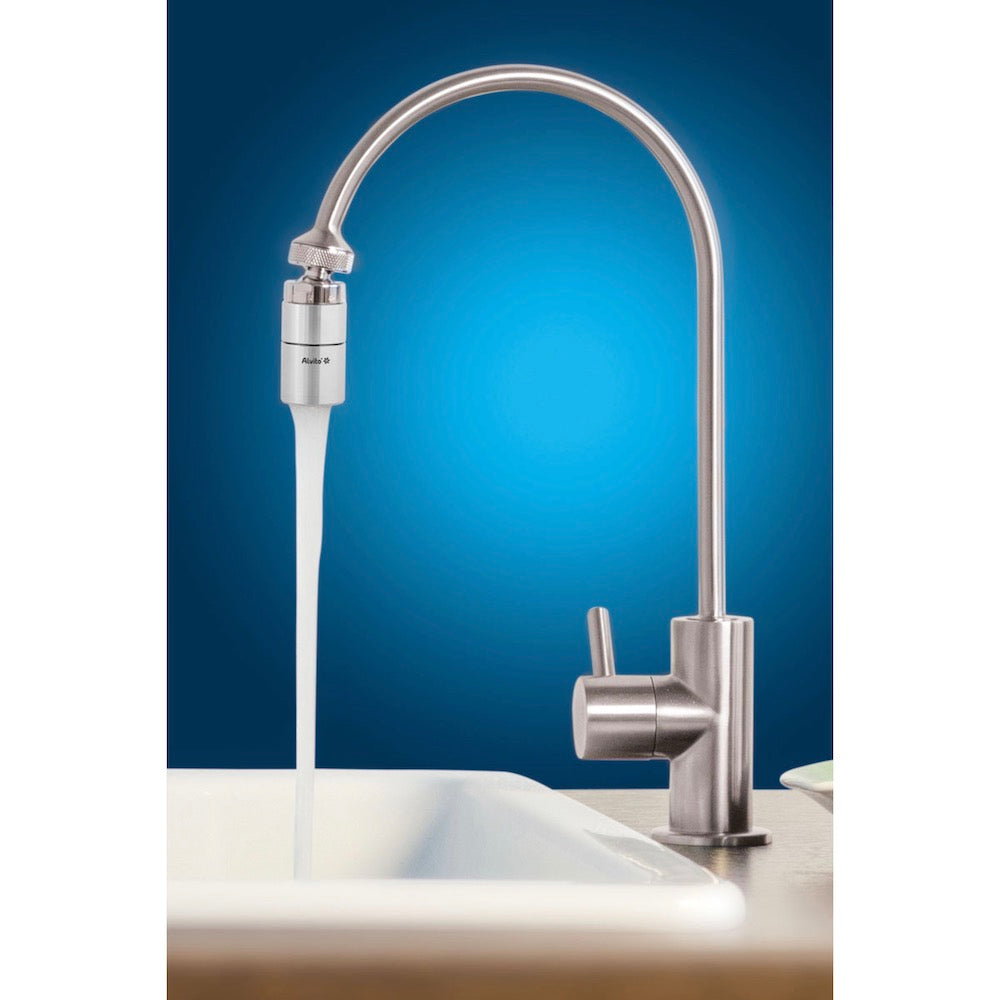 Eine moderne Küchenarmatur aus Edelstahl mit einem hohen, geschwungenen Auslauf liefert belebtes Leitungswasser - dank des Alvito Wasserwirblers VIVA (2.8) von Alvito - in eine weiße Spüle vor einem leuchtend blauen Hintergrund.
