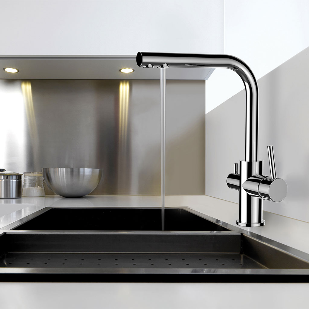 Die Paola 3-Wege-Wasserhahn Chrom bietet fließendes Wasser über einer schwarzen Spüle in einer schlichten, minimalistischen Küche mit einer Aufkantung aus Edelstahl und einer Rührschüssel aus Metall auf dem Tresen.