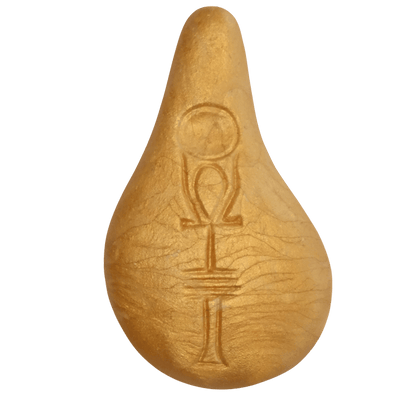 Der Stein der Harmonie ist ein goldenes, tropfenförmiges Objekt aus organischem Holzgemisch mit eingravierten Symbolen - einem Kreis, einem Omega und horizontalen Linien - auf seiner Oberfläche.